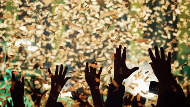 hands raised in air amid confetti