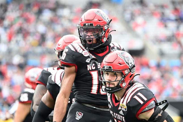 Dec 30, 2022; Charlotte, NC, USA; North Carolina State Wolfpack safety Rakeim Ashford (16) reacts with linebacker Payton Wilson (11) after intercepting the ball in the fourth quarter in the 2022 Duke's Mayo Bowl at Bank of America Stadium.