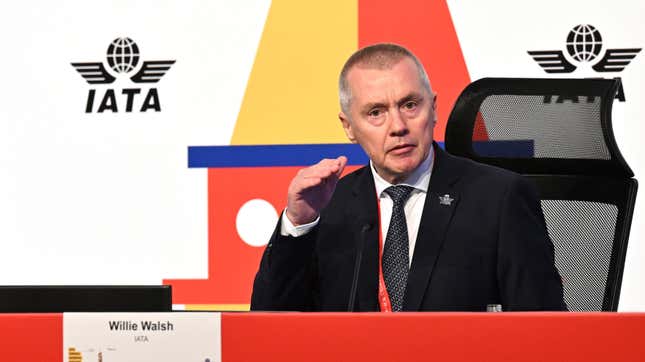 Willie Walsh seated at a table behind a sign with his name.