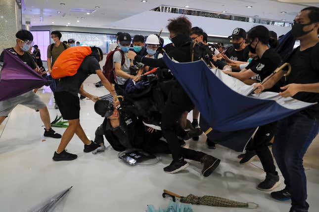 A policeman is attacked by protesters inside a mall in Sha Tin in Hong Kong, July 14, 2019.