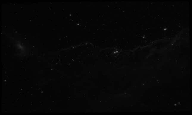 A raw image of the Carina Nebula as seen by NIRCam is mostly black to the human eye, with some white specks from some light sources. It is clear that infrared light cannot be seen by the human eye.