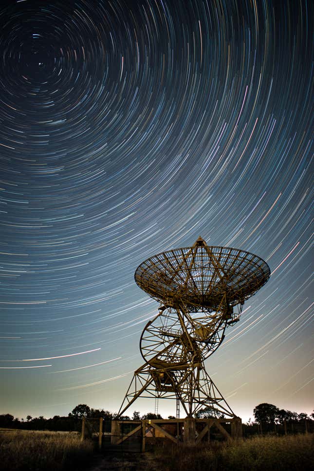 Streaks of stars over a radio telescope antenna at Mullard Radio Astronomy Observatory.