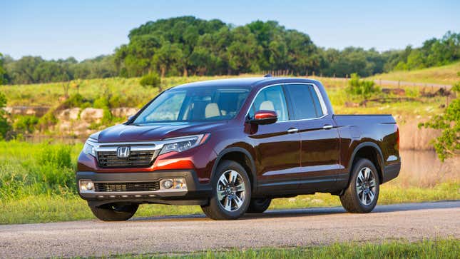 A photo of a burgundy Honda Ridgeline truck on a country road. 
