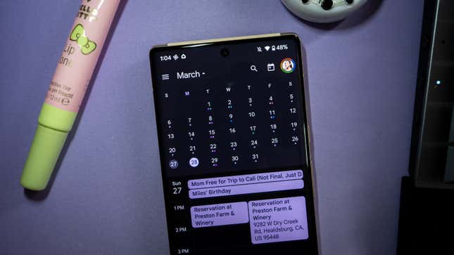 A photo of a phone showing Google Calendar in the month of March 