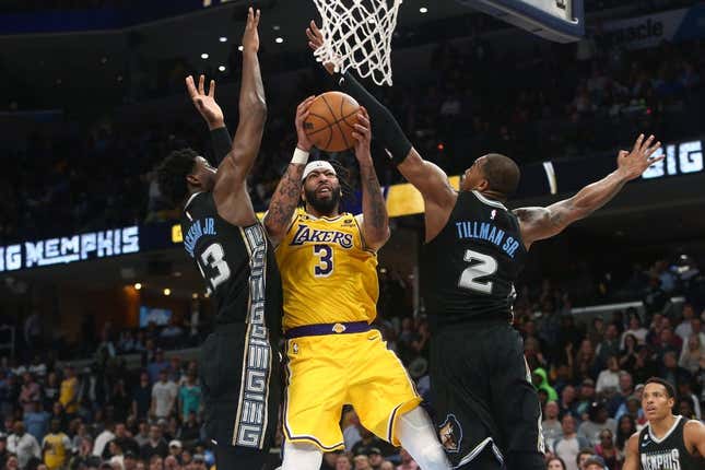 Feb 28, 2023; Memphis, Tennessee, USA; Los Angeles Lakers forward Anthony Davis (3) drives to the basket between Memphis Grizzlies forward Jaren Jackson Jr. (13) and forward Brandon Clark (15) during the second half at FedExForum.