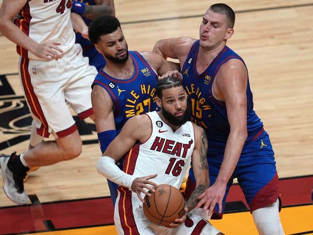 Jun 7, 2023; Miami, Florida, USA; Miami Heat forward Caleb Martin (16) attempts to dribble the ball against Denver Nuggets guard Jamal Murray (27) and center Nikola Jokic (15) during the first quarter in game three of the 2023 NBA Finals at Kaseya Center.