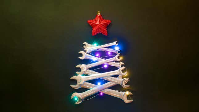 A Christmas tree made of overlaying wrenches, decorated with lights and a sparkly red star ornament on top on a plane green background