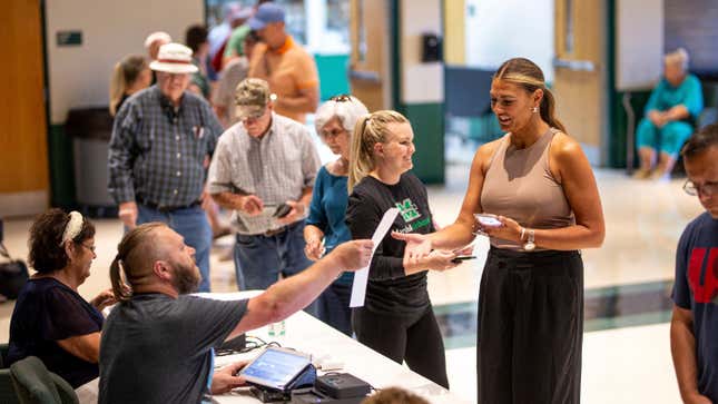 Die Wähler erhalten ihre Stimmzettel, während Einwohner des Lawrence County während einer Sonderwahl zu einem Thema am 8. August 2023 an der Fairland High School in Proctorville, Ohio, zu den Urnen gehen, um über Ohio Issue 1 abzustimmen.