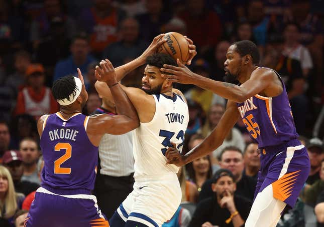 Mar 29, 2023; Phoenix, Arizona, USA; Minnesota Timberwolves center Karl-Anthony Towns (32) controls the ball against Phoenix Suns forward Josh Okogie (2) and Kevin Durant (35) in the first half at Footprint Center.