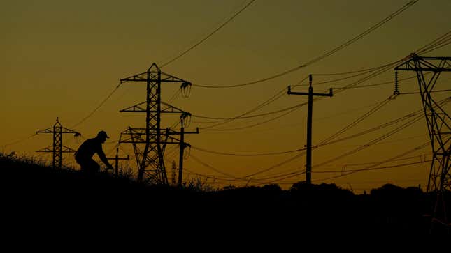 A cyclist passes power lines during an evening ride on Monday, June 26, 2023, in San Antonio. 