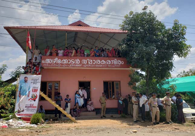 People seek shade by the Communist coalition office while they wait for Priyanka Gandhi’s address.