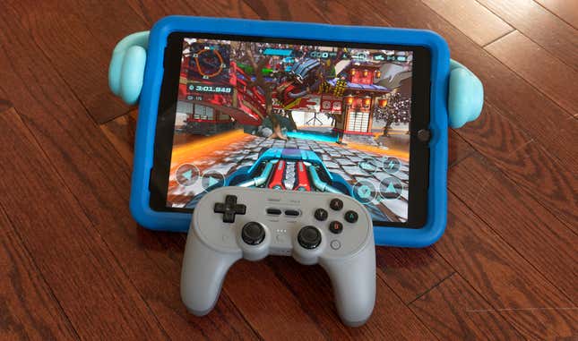 An 8BitDo Pro 2 controller sitting on an Apple iPad running the Hot Wheels: Rift Rally app.