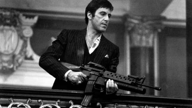 Al Pacino holding a gun and wearing a suit in Scarface.