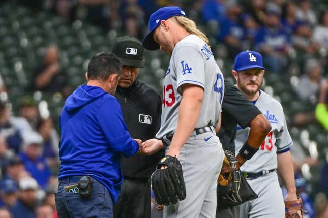 May 9, 2023; Milwaukee, Wisconsin, USA; Los Angeles Dodgers pitcher Noah Syndergaard (43) is checked by a trainer in the first inning during game against the Milwaukee Brewers at American Family Field. Syndergaard later left the game with a possible hand injury.
