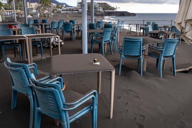 Ash covers tables and chairs on a bar terrace at the promenade of Puerto Naos village.