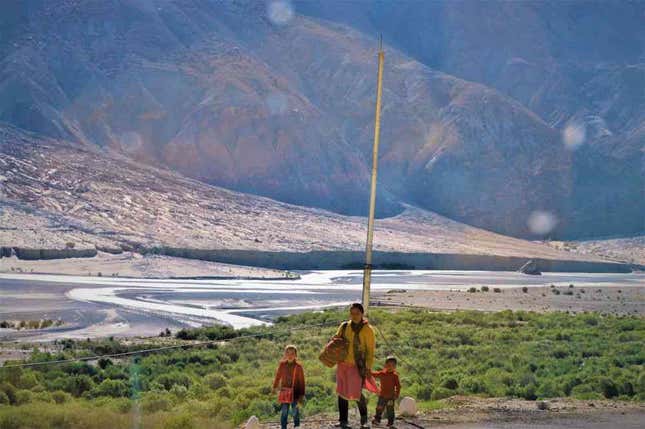 A woman and two children walk along the banks of the Shyok river.