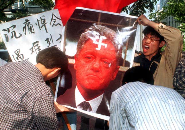 Chinese students try to burn a photo depicting Bill Clinton to protest the NATO bombing of the Chinese embassy in Belgrade, near the US embassy in Seoul, May 13, 1999.