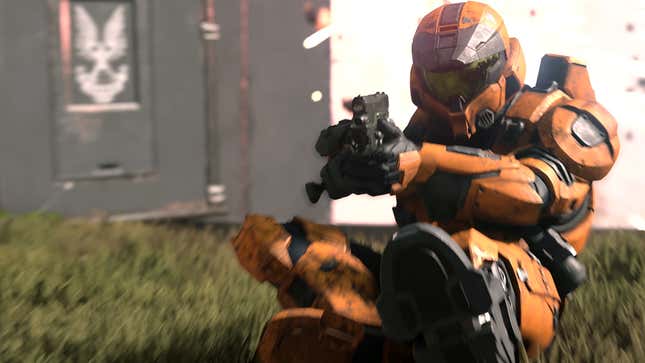 A screenshot from Halo Infinite's multiplayer reveal, showing an orange-colored spartan sliding while aiming down the sights of what appears to be a pistol. 