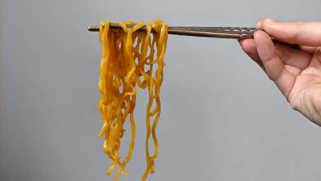 Pumpkin Spice Nissin Cup Noodles hanging from chopsticks