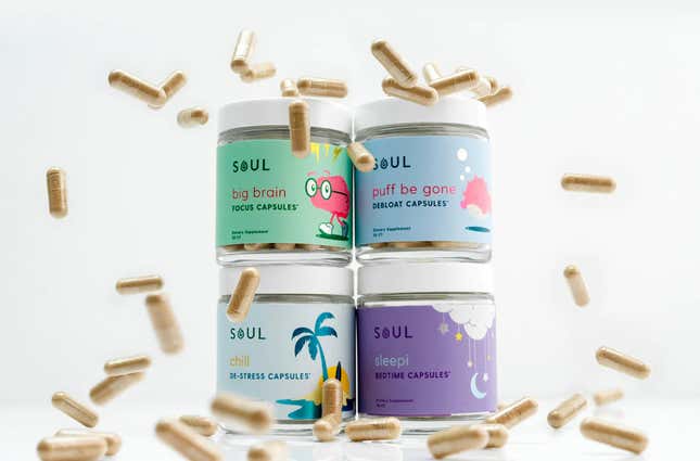 Four containers of Soul's CBD capsules with capsules raining down on them. 