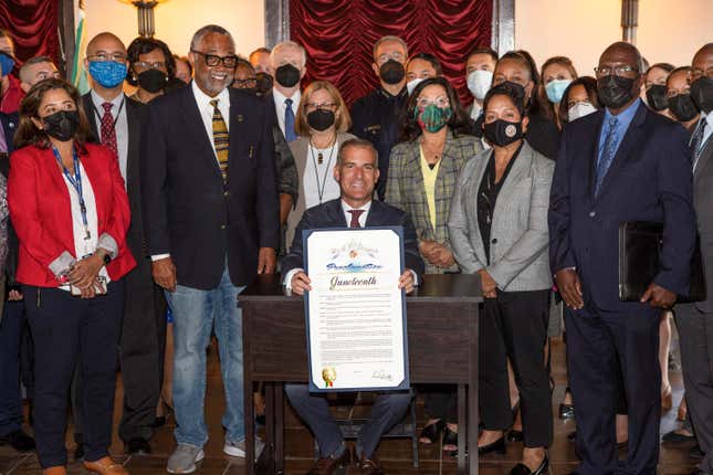 This photo provided by the Office of Los Angeles Mayor Eric Garcetti shows Garcetti joined by Councilmember Curren Price and other city officials after signing a proclamation making Juneteenth an official City holiday on Monday, June 6, 2022, at LA City Hall in Los Angeles.