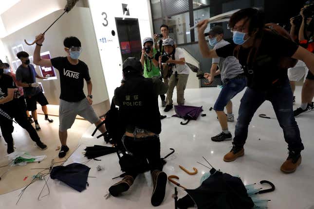 Pro-democracy activists hit a plainclothes police officer in a Hong Kong mall, July 14, 2019.