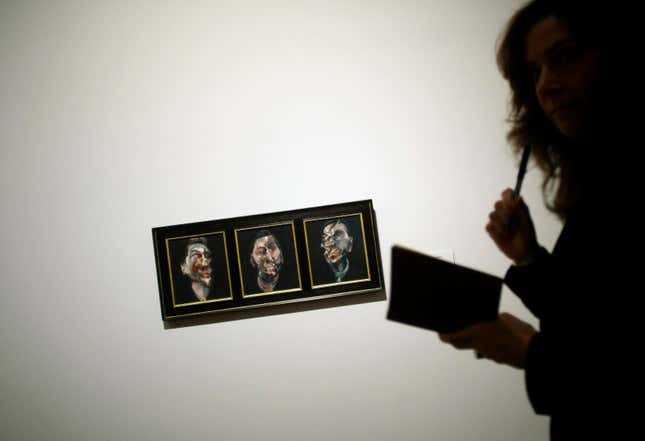 A woman stands next to the painting "Three Studies for a Portrait of George Dyer" by Irish-born artist Francis Bacon