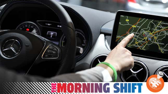 A Getty photo of a person using satellite navigation in a Mercedes-Benz in 2015, with the Jalopnik "The Morning Shift" banner over top.