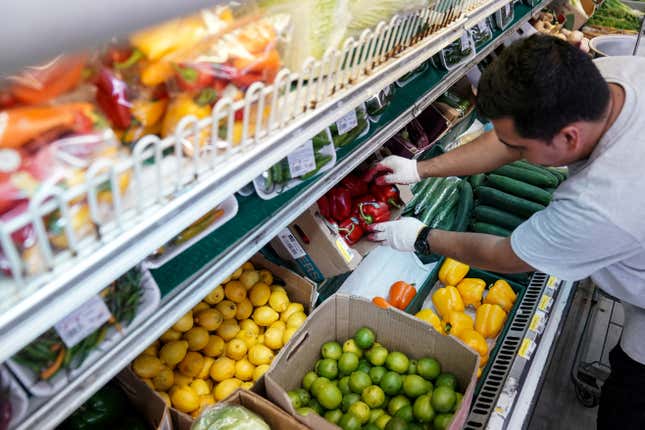A man arranges produce at Best World Supermarket in the Mount Pleasant neighborhood of Washington, D.C., U.S., August 19, 2022. 