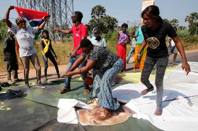 Supporters of president-elect Adama Barrow dance on a poster of Jammeh during celebrations (Reuters/Thierry Gouegnon)