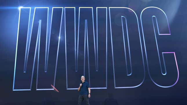 Apple CEO Tim Cook stands in front of a giant WWDC sign.