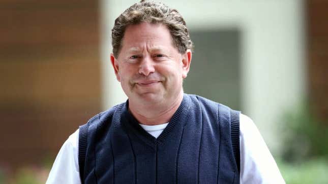 Kotick wears a sweater and a TV shirt as he half-smiles. 