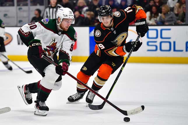 Jan 28, 2023; Anaheim, California, USA; Arizona Coyotes defenseman J.J. Moser (90) moves the puck against Anaheim Ducks right wing Troy Terry (19) during the third period at Honda Center.