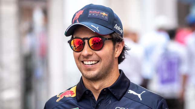 A photo of Sergio Perez wearing his Red Bull gear and dark sunglasses. 