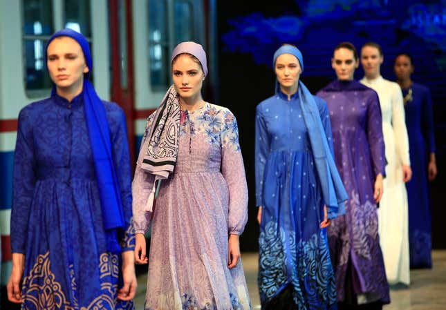 Models hit the catwalk of a fashion show during the International Modest Fashion Week, in Istanbul, Friday, May, 13, 2016. Turkeys first International Modest Fashion Week has opened in Istanbul bringing designers and models of conservative wear from around the world. The two-day event kicked off Friday with models hitting the runway at a historic train station donning a bright palette of breezy garment and kaleidoscopic headscarves. (AP Photo/Lefteris Pitarakis)