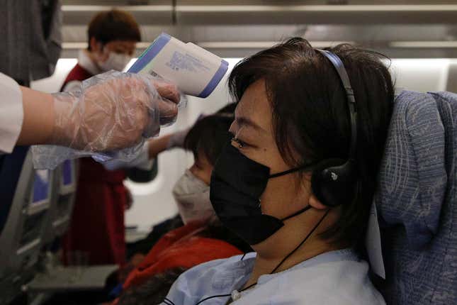 Close range: Flight attendants wielding the temperature gun aboard a flight from Melbourne to Beijing.