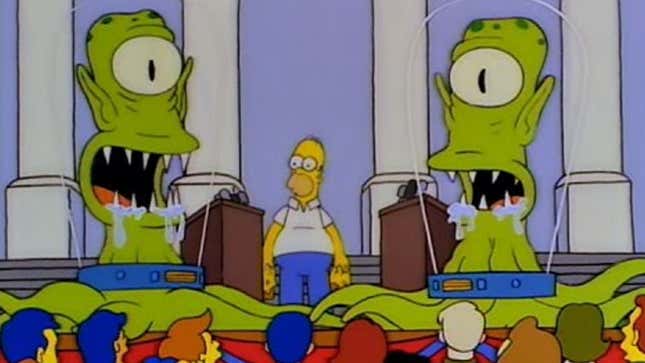 A screenshot from The Simpsons shows two large aliens near Homer. 