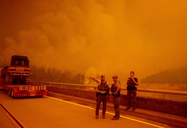  Law enforcement and fire personnel wait on the Enterprise Bridge to enter an area encroached by fire during the Bear fire, part of the North Lightning Complex fires, in unincorporated Butte County, in Oroville, California, on Sept. 9, 2020.