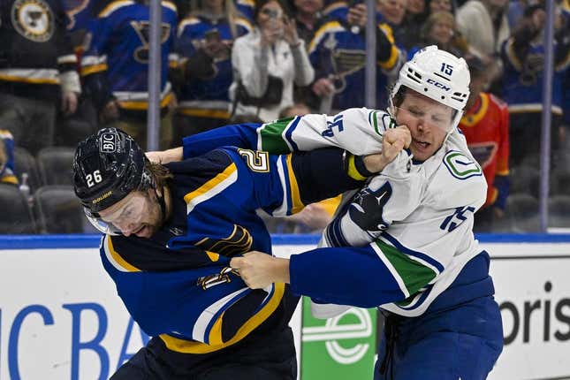 Feb 23, 2023; St. Louis, Missouri, USA;  Vancouver Canucks center Sheldon Dries (15) and St. Louis Blues left wing Nathan Walker (26) fight during the third period at Enterprise Center.
