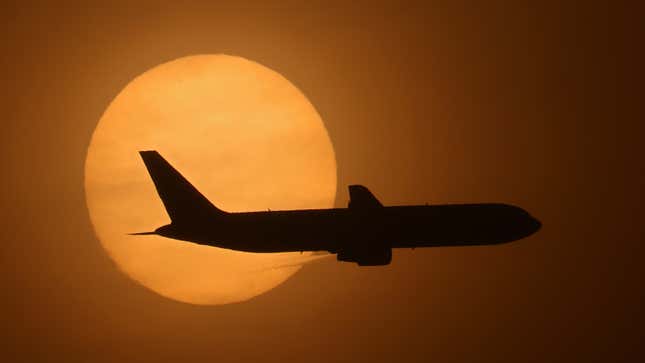 A cargo plane on its final approach into Long Beach Airport passes in front a hazy sun caused by smoke from the nearby Silverado Fire on Oct. 26, 2020.