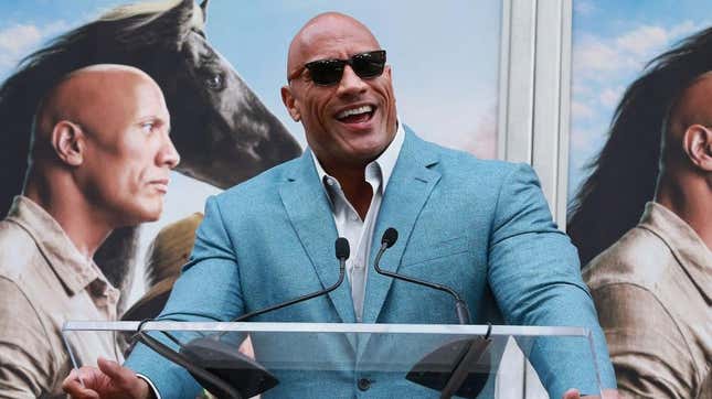Dwayne "The Rock" Johnson in a blue suit and sunglasses