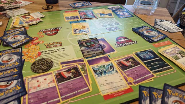 A Pokemon TCG game in full flow, cards all over a green board.
