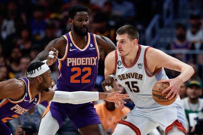 May 9, 2023; Denver, Colorado, USA; Denver Nuggets center Nikola Jokic (15) controls the ball under pressure from Phoenix Suns center Deandre Ayton (22) and forward Josh Okogie (2) in the first quarter during game five of the 2023 NBA playoffs at Ball Arena.