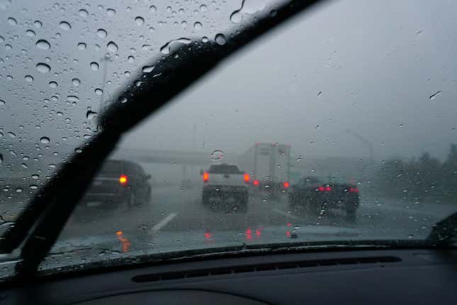 Cars driving on the freeway in the rain and fog.