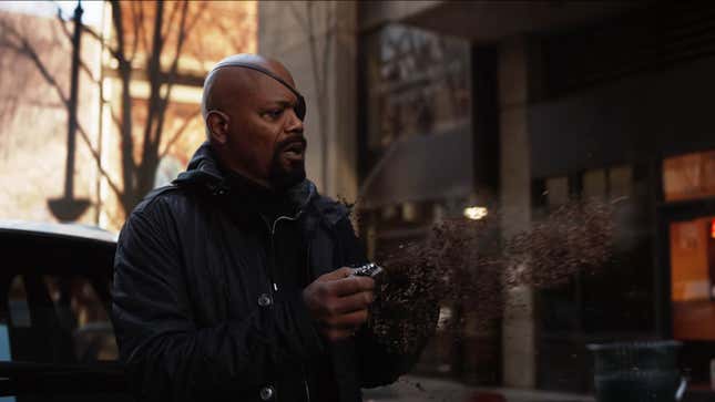 Holding a pager in one hand, Nick Fury watches the other dissolve into ash.