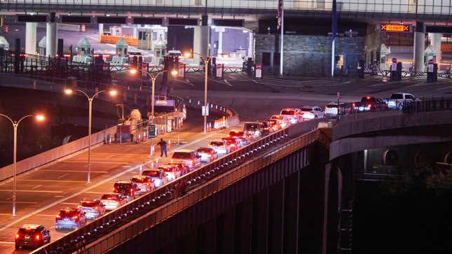 A line of Canadian passenger cars stretches across the Rainbow Bridge between Niagara Falls, Ontario and Niagara Falls, New York on November 7, 2021, just before midnight.
