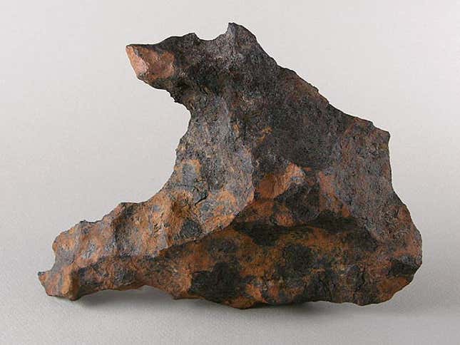 A mottled grey-brown space rock.