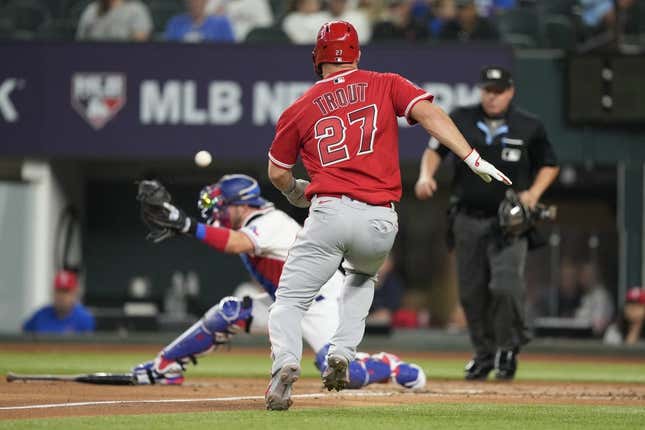 Jun 14, 2023; Arlington, Texas, USA; Los Angeles Angels center fielder Mike Trout (27) runs home to score as Texas Rangers catcher Mitch Garver (18) is unable to catch the throw during the third inning at Globe Life Field.