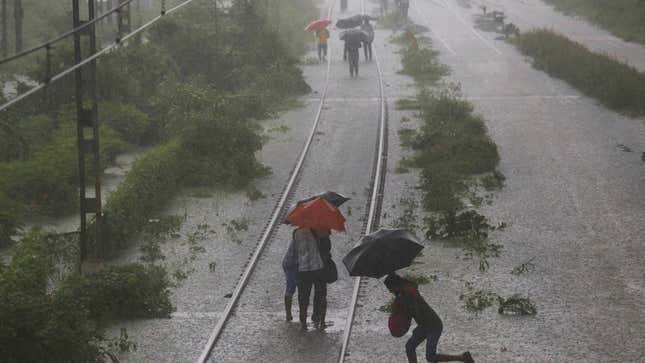 Commuters walking on a flooded railway track on Sept. 04, after heavy rainfall in Mumbai.