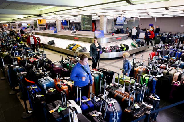 DENVER, CO - DECEMBER 28: Travelers search for their suitcases in a baggage holding area for Southwest Airlines at Denver International Airport on December 28, 2022 in Denver, Colorado. More than 15,000 flights have been canceled by airlines since winter weather began impacting air travel on December 22. 